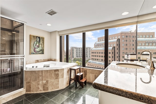 bathroom with a relaxing tiled tub and sink