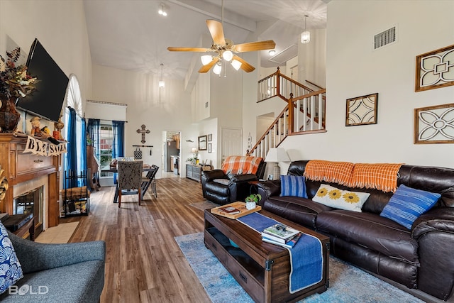 living room featuring beamed ceiling, hardwood / wood-style floors, high vaulted ceiling, and ceiling fan