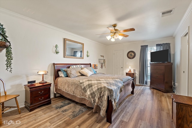 bedroom with hardwood / wood-style flooring, crown molding, and ceiling fan