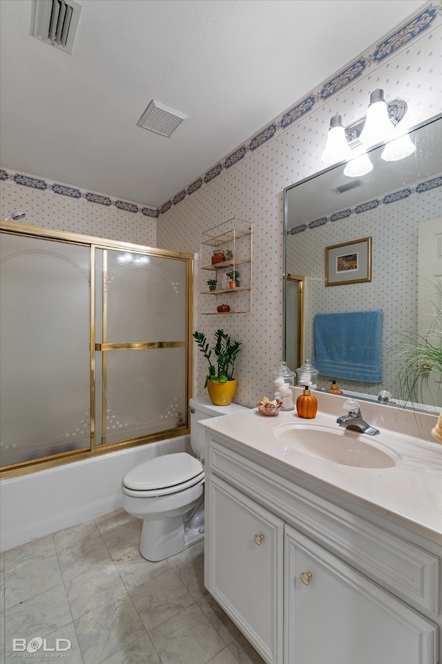 full bathroom with a textured ceiling, combined bath / shower with glass door, vanity, and toilet