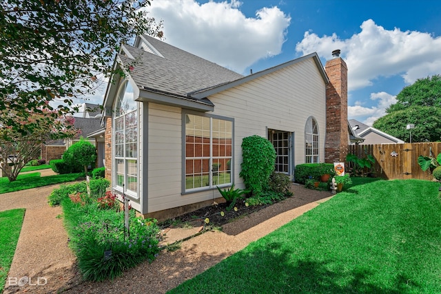 view of side of home with a yard