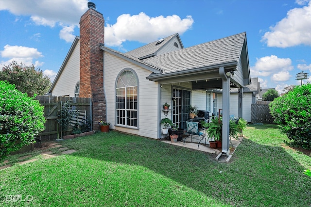 rear view of property with a patio and a lawn