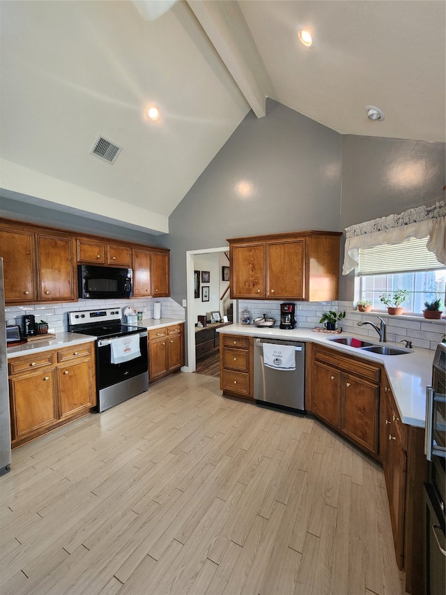 kitchen featuring beam ceiling, stainless steel appliances, backsplash, and sink