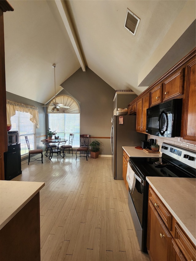 kitchen with stainless steel range with electric stovetop, hanging light fixtures, lofted ceiling with beams, and light hardwood / wood-style floors