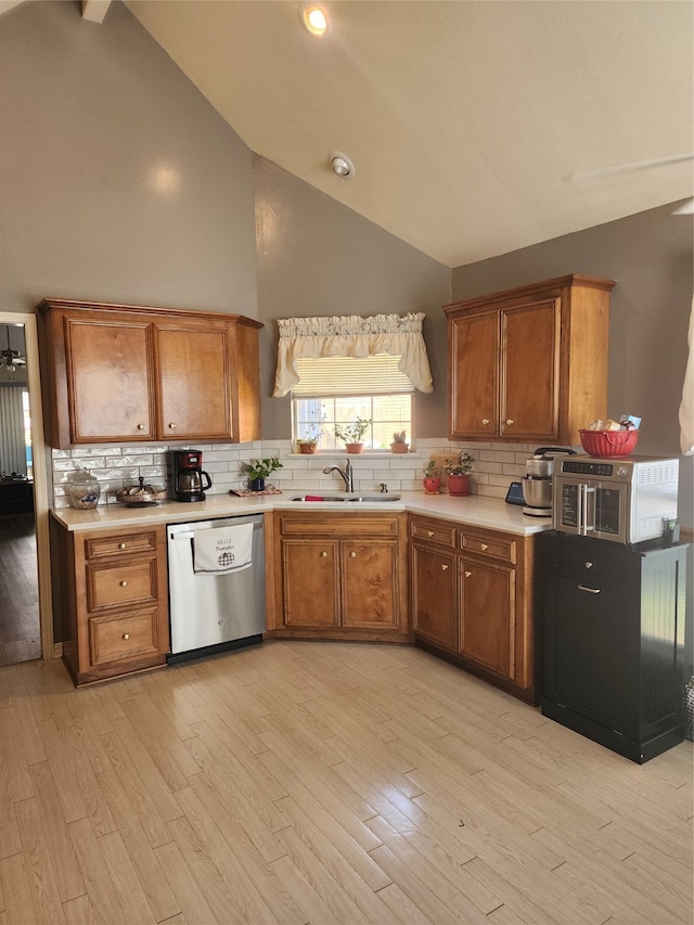 kitchen with light hardwood / wood-style floors, decorative backsplash, sink, dishwasher, and high vaulted ceiling