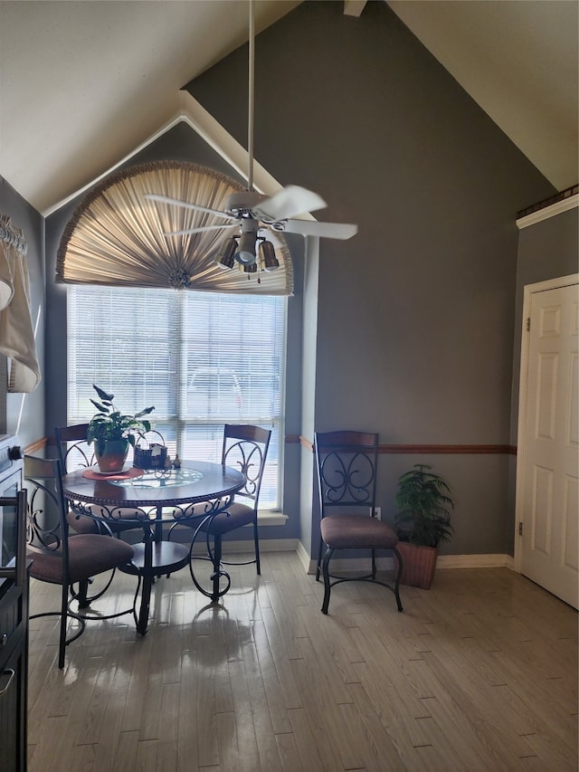 dining room featuring hardwood / wood-style floors, a healthy amount of sunlight, and vaulted ceiling