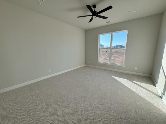 spare room featuring light carpet and ceiling fan