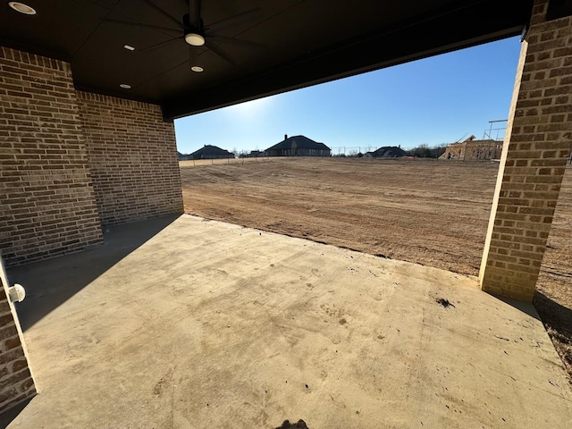 view of yard with ceiling fan and a patio area