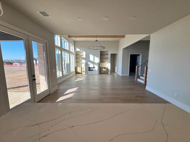 unfurnished living room with wood-type flooring and french doors