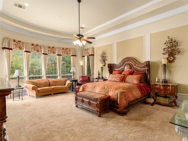 carpeted bedroom featuring multiple windows, ornamental molding, ceiling fan, and a raised ceiling