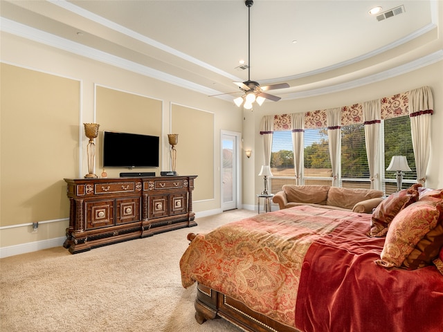 carpeted bedroom featuring ornamental molding, ceiling fan, and a raised ceiling