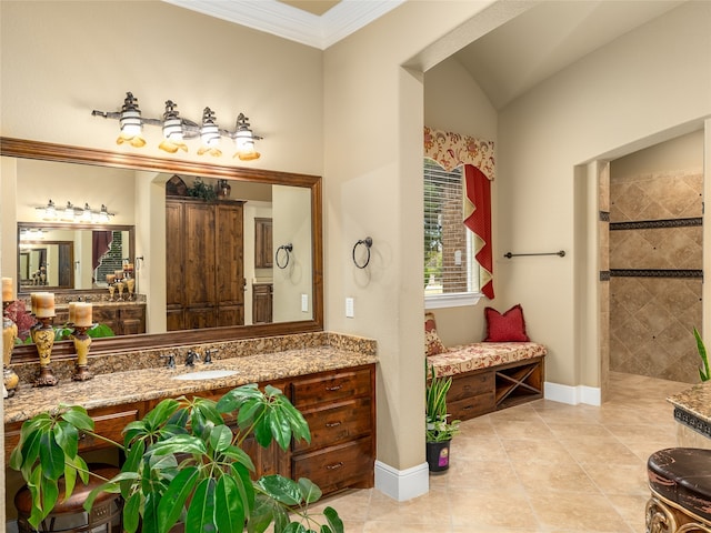 bathroom with vanity, crown molding, a tile shower, and tile patterned floors