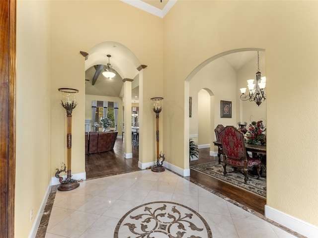 entrance foyer featuring a towering ceiling, light hardwood / wood-style flooring, and a notable chandelier