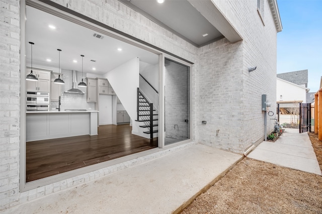 exterior space featuring a patio, brick siding, exterior kitchen, and visible vents