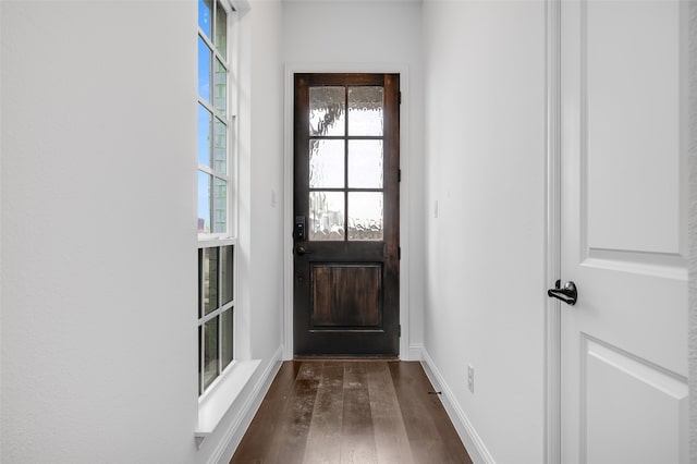 doorway featuring dark wood-style floors and baseboards