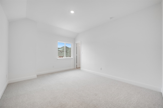 unfurnished room featuring vaulted ceiling, recessed lighting, light carpet, and baseboards