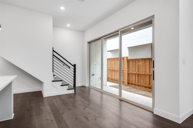 interior space featuring baseboards, dark wood-type flooring, and a wealth of natural light