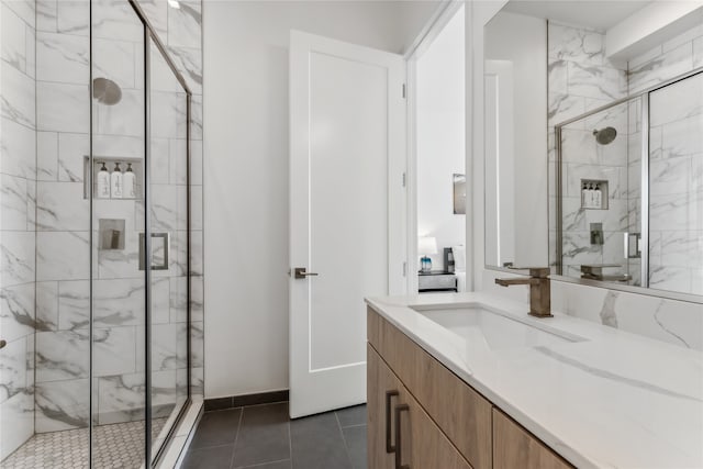 bathroom with tile patterned floors, vanity, and a shower with door