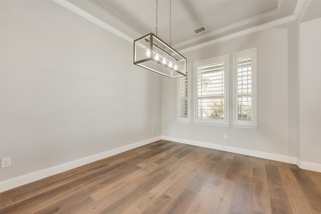 unfurnished dining area featuring wood-type flooring, a chandelier, and ornamental molding