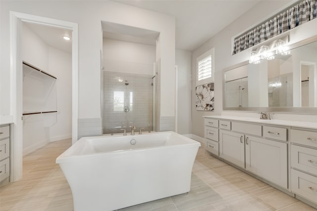 bathroom featuring independent shower and bath, tile patterned flooring, and vanity