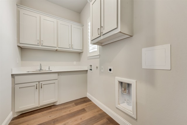 clothes washing area with cabinets, sink, electric dryer hookup, light hardwood / wood-style flooring, and hookup for a washing machine