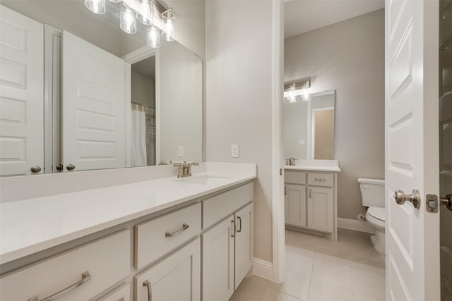 bathroom with tile patterned flooring, vanity, and toilet