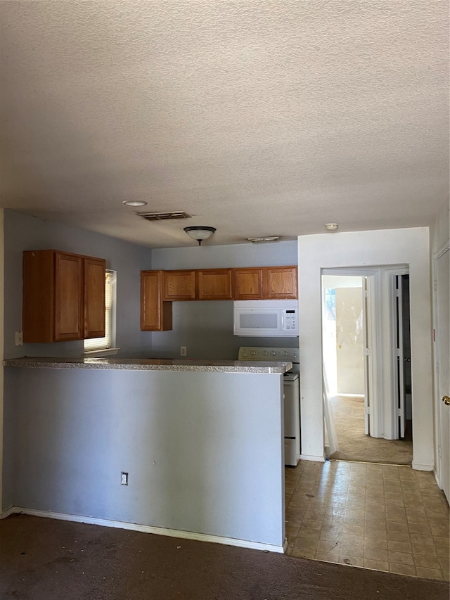 kitchen with white appliances and a textured ceiling