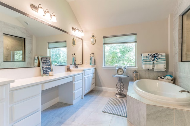 bathroom with vanity, a wealth of natural light, and vaulted ceiling