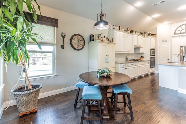 dining area with sink, dark hardwood / wood-style flooring, and vaulted ceiling