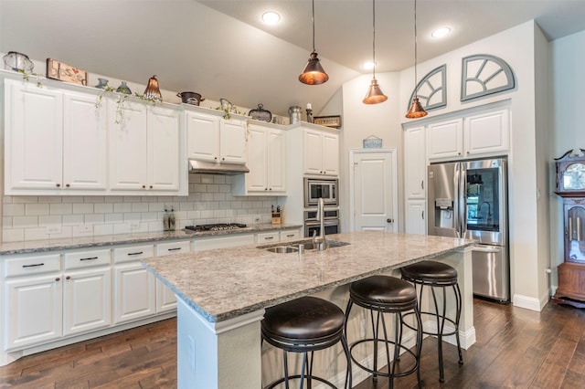 kitchen with stainless steel appliances, white cabinets, and a center island with sink