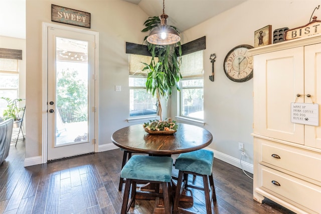 dining space featuring vaulted ceiling and dark hardwood / wood-style floors