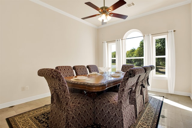 tiled dining space featuring ornamental molding, a wealth of natural light, and ceiling fan