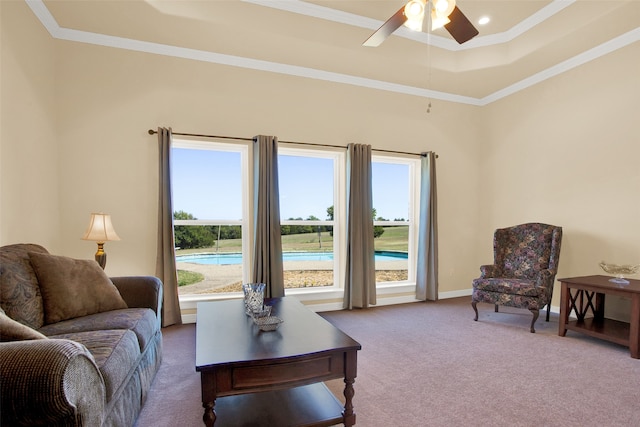 carpeted living room with ceiling fan and ornamental molding