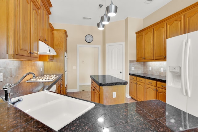 kitchen with backsplash, white appliances, pendant lighting, a center island, and sink