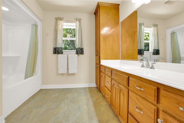 bathroom featuring tile patterned floors, vanity, shower / bath combo with shower curtain, and a healthy amount of sunlight