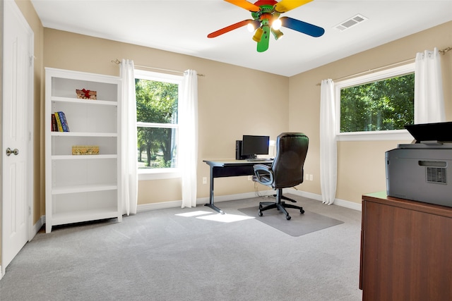 carpeted office space with ceiling fan