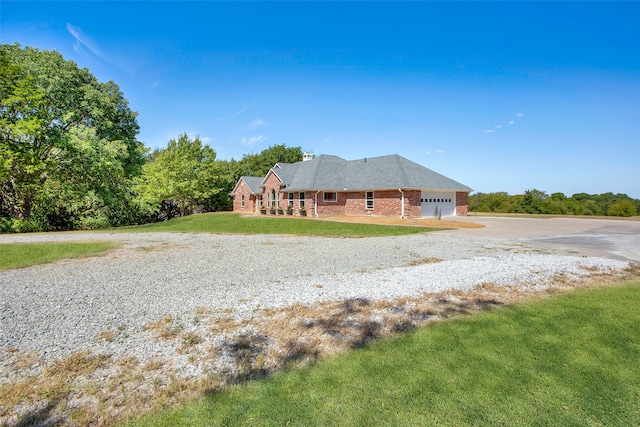 ranch-style home featuring a garage and a front lawn