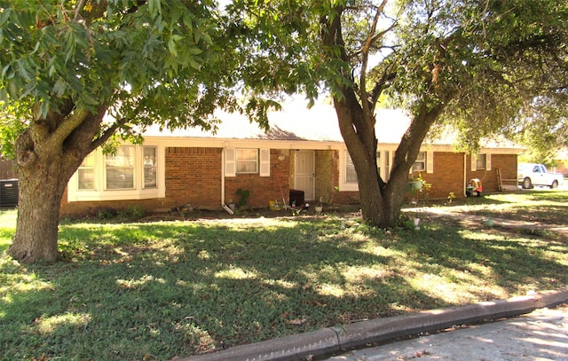 single story home with central AC and a front yard