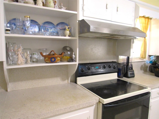 kitchen featuring black / electric stove and white cabinets