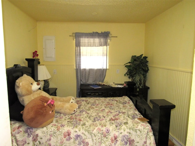 bedroom with a textured ceiling and electric panel