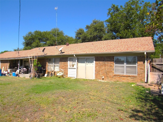 rear view of property featuring a lawn