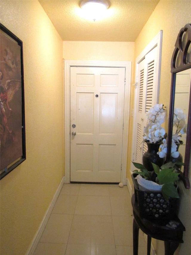 entryway with light tile patterned flooring and a textured ceiling