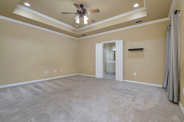 unfurnished bedroom with light carpet, a tray ceiling, ceiling fan, and crown molding