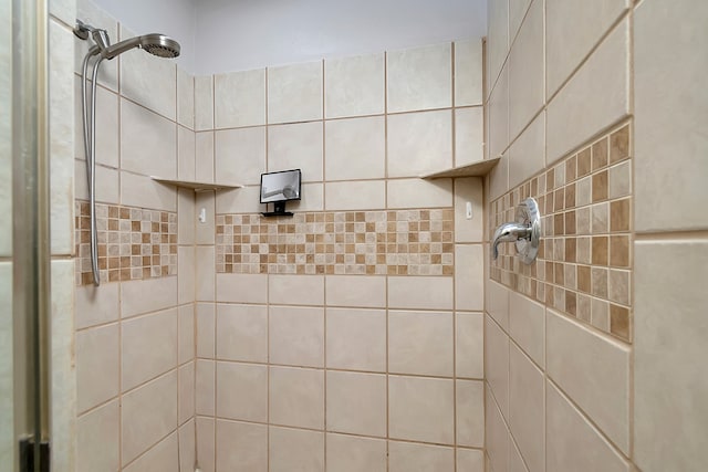 bathroom with a tile shower and tile walls