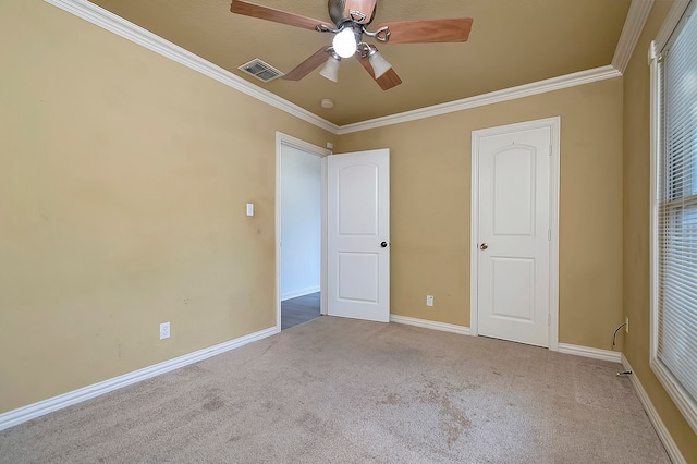 unfurnished bedroom featuring ceiling fan, light colored carpet, and crown molding