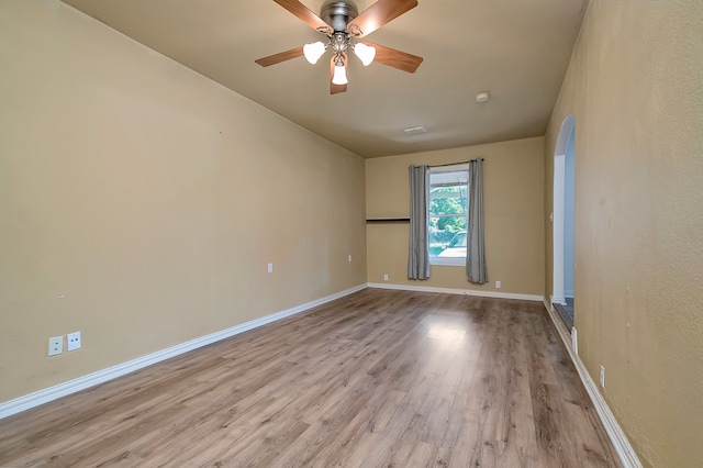 empty room with ceiling fan and light hardwood / wood-style flooring