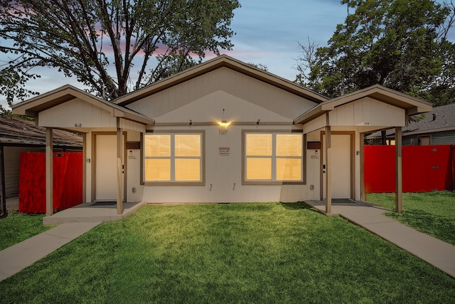 view of front of house with a yard and fence