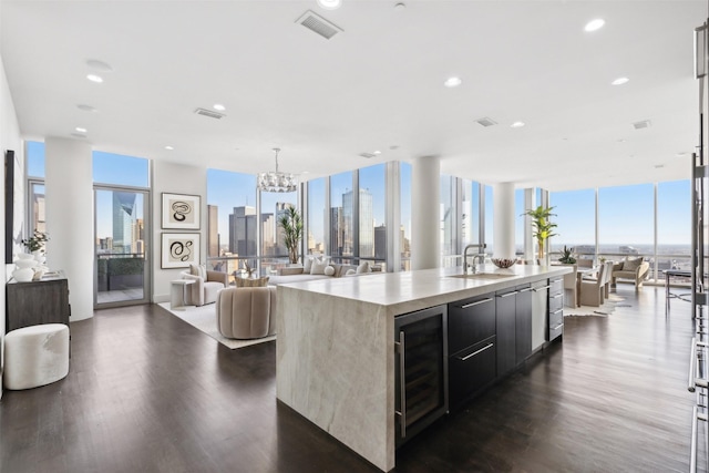 kitchen featuring wine cooler, a large island with sink, sink, and dark wood-type flooring