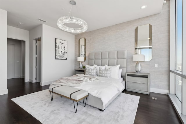 bedroom featuring dark hardwood / wood-style flooring and an inviting chandelier