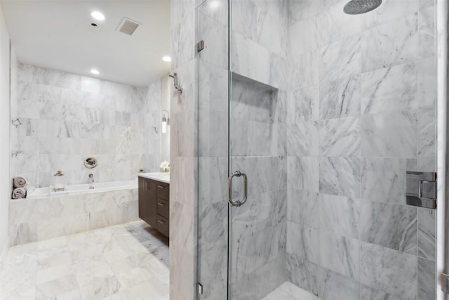 bathroom with vanity and shower with separate bathtub